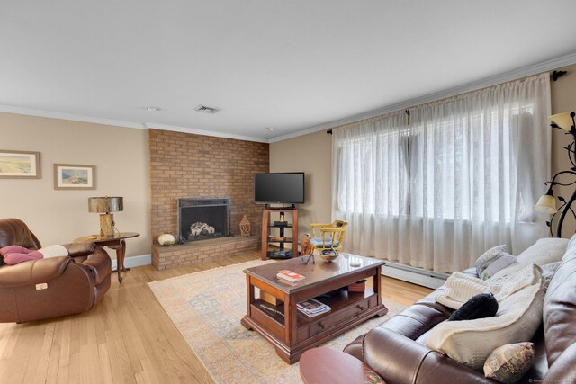 living room featuring visible vents, ornamental molding, a brick fireplace, and wood finished floors