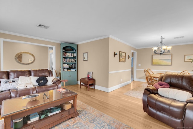 living area featuring baseboards, visible vents, light wood finished floors, crown molding, and a notable chandelier