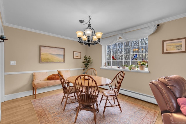 dining area with a baseboard radiator, an inviting chandelier, wood finished floors, and crown molding