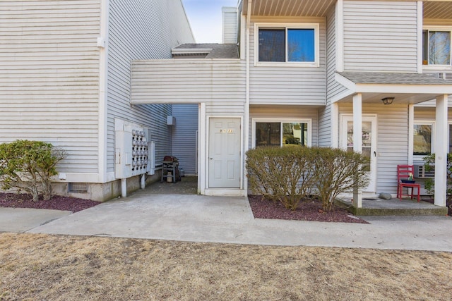 doorway to property featuring roof with shingles