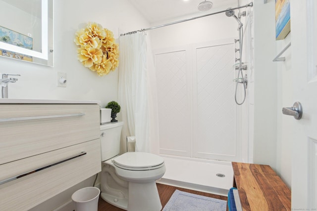 bathroom featuring vanity, a shower with shower curtain, toilet, and wood finished floors