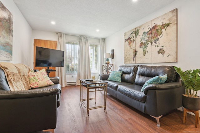 living area with recessed lighting, a baseboard radiator, a textured ceiling, and wood finished floors