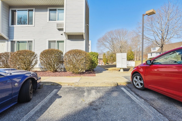 view of property exterior featuring mail area and uncovered parking