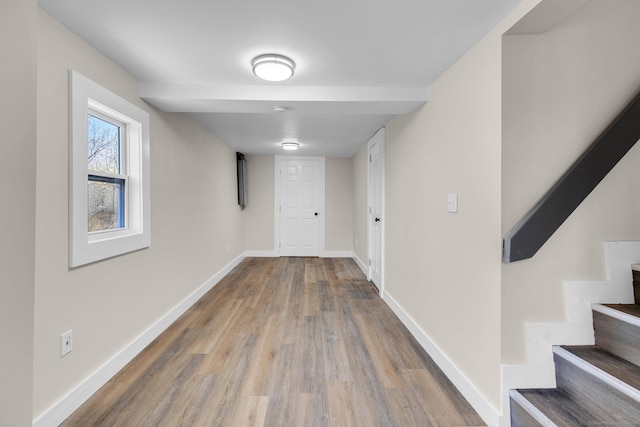 corridor with stairway, baseboards, and wood finished floors