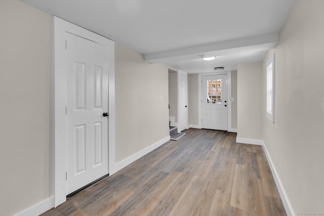 hallway with baseboards, wood finished floors, and stairs