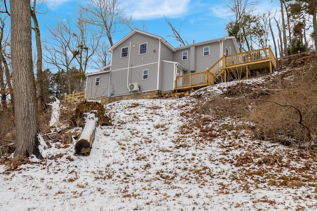 snow covered property featuring stairs and a deck