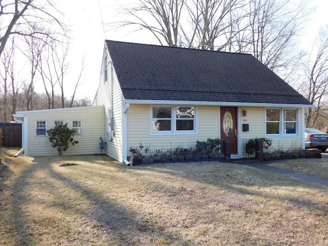 view of front of property featuring a front yard and roof with shingles