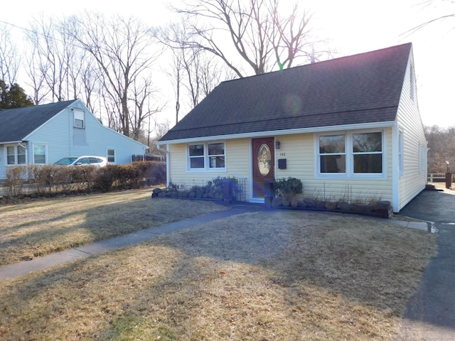 view of front of home with a front yard and roof with shingles