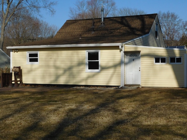 rear view of property featuring a yard