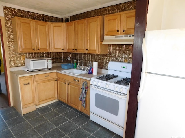 kitchen featuring under cabinet range hood, light countertops, decorative backsplash, white appliances, and a sink