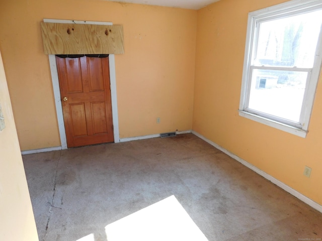 carpeted empty room featuring visible vents and baseboards