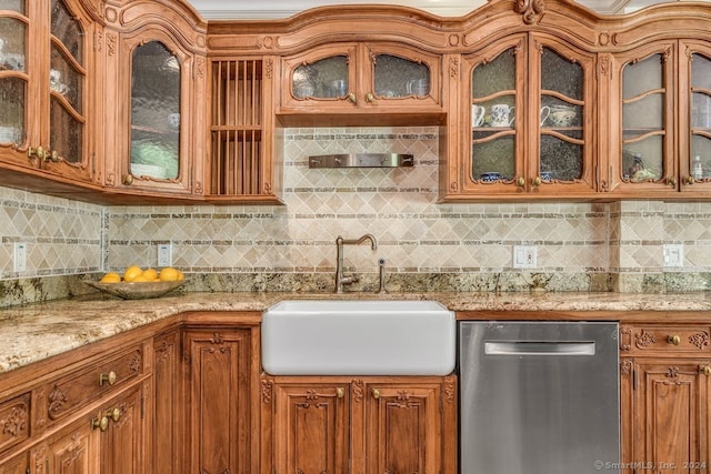 kitchen featuring light stone counters, decorative backsplash, stainless steel dishwasher, and a sink