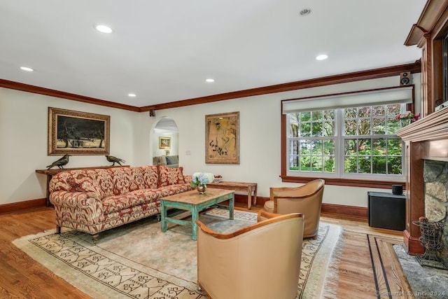 living room with crown molding, light wood-style floors, and baseboards