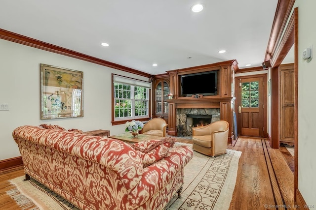 living room with recessed lighting, light wood-style floors, a fireplace, crown molding, and baseboards