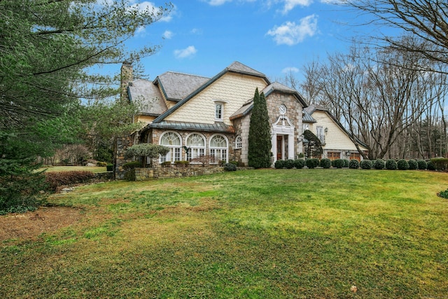 view of front of property featuring a chimney and a front yard