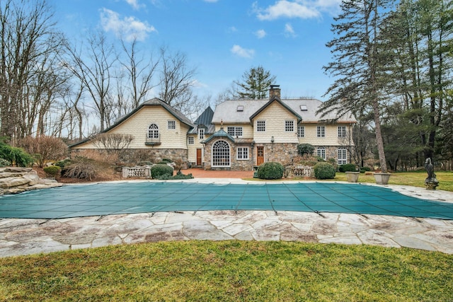 view of swimming pool with a covered pool, a lawn, and a patio