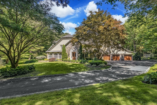23 Benedict Hill Rd, New Canaan, CT 06840 - view of front of house featuring asphalt driveway, stone siding, a front lawn, and a garage