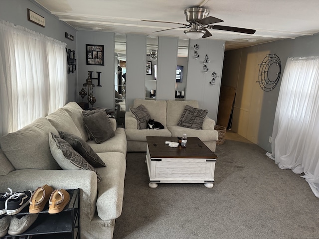 carpeted living area with a ceiling fan