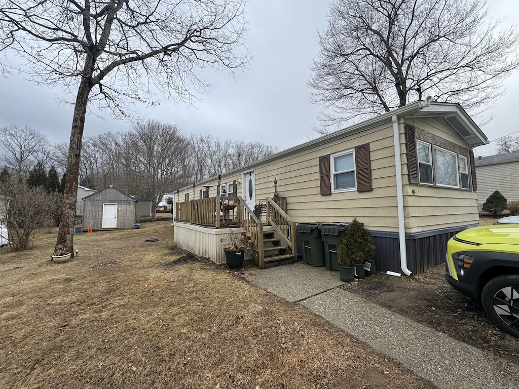 exterior space with a deck, a storage unit, and an outdoor structure