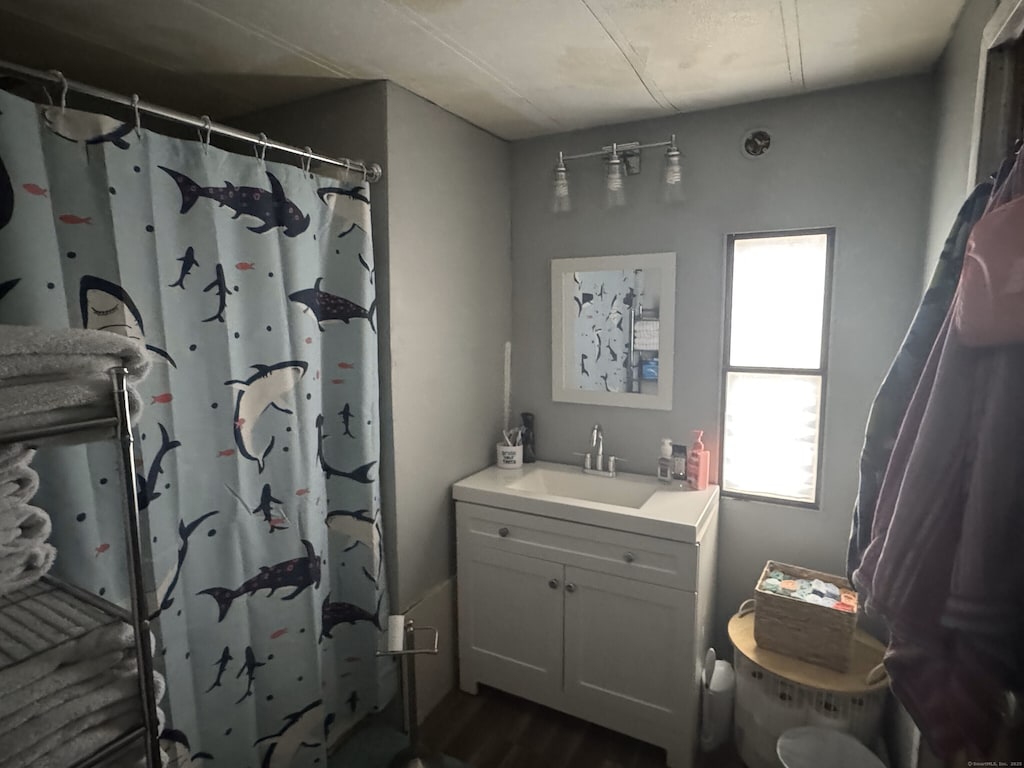 bathroom featuring curtained shower, toilet, and vanity