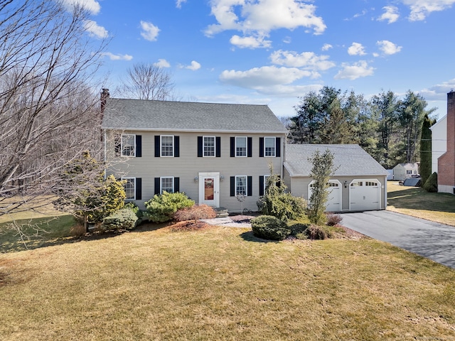 colonial home featuring driveway, a front lawn, and a garage