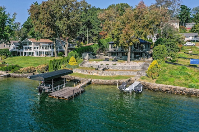 view of dock with stairway, a water view, boat lift, and a lawn