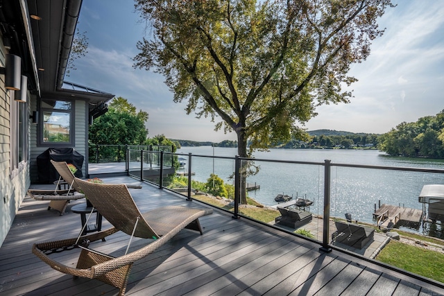 wooden terrace featuring a grill and a water view