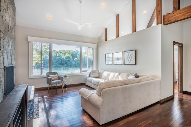 living area featuring plenty of natural light, high vaulted ceiling, dark wood-style flooring, and a fireplace