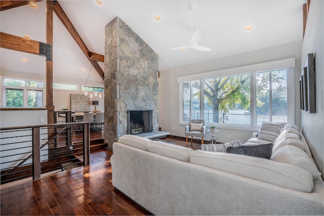 living room featuring beamed ceiling, plenty of natural light, dark wood-style floors, and a fireplace