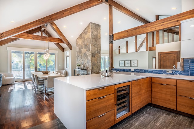 kitchen with modern cabinets, beverage cooler, backsplash, open floor plan, and light countertops