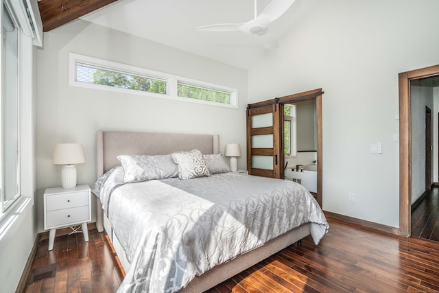 bedroom featuring a barn door, multiple windows, visible vents, and hardwood / wood-style flooring