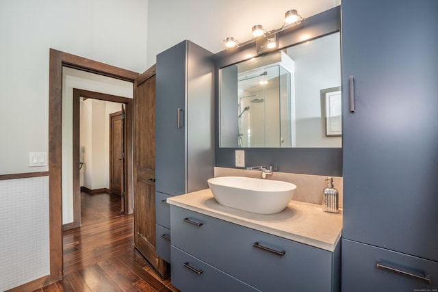 bathroom with vanity, a shower, and wood finished floors