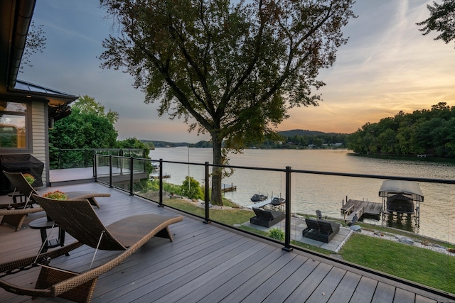 deck with a water view and area for grilling