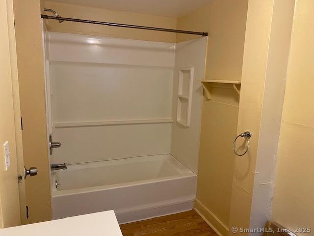 full bathroom with shower / bathing tub combination and wood finished floors