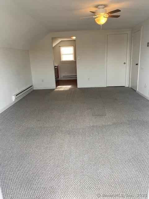 bonus room with a baseboard heating unit, carpet floors, baseboard heating, ceiling fan, and vaulted ceiling