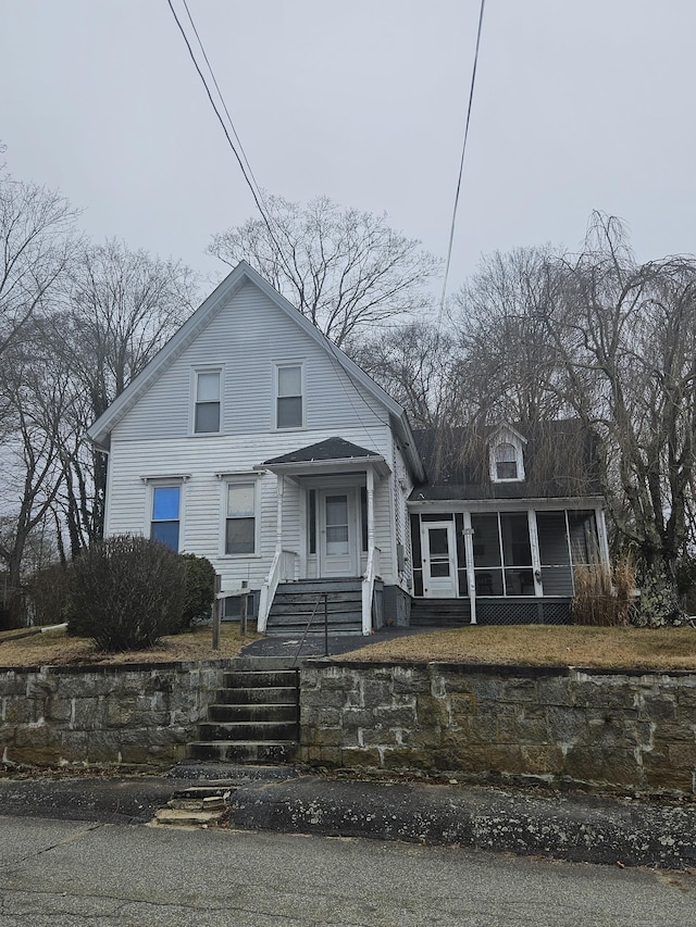 view of front facade featuring a gambrel roof and a sunroom