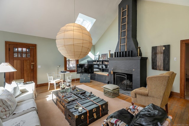 12 Old Forge Hollow Rd, Litchfield, CT 06750 - living room featuring a skylight, high vaulted ceiling, wood finished floors, and a brick fireplace