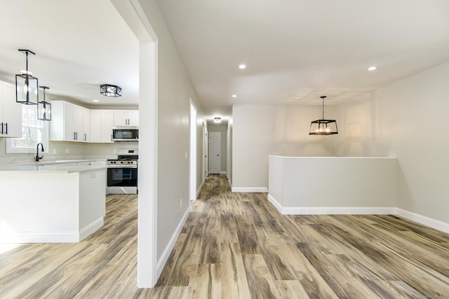 interior space with light wood finished floors, stainless steel appliances, light countertops, and recessed lighting