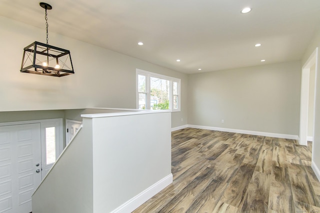 foyer entrance featuring baseboards, a notable chandelier, wood finished floors, and recessed lighting
