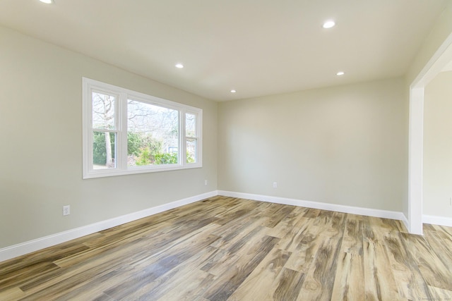 unfurnished room featuring recessed lighting, wood finished floors, and baseboards