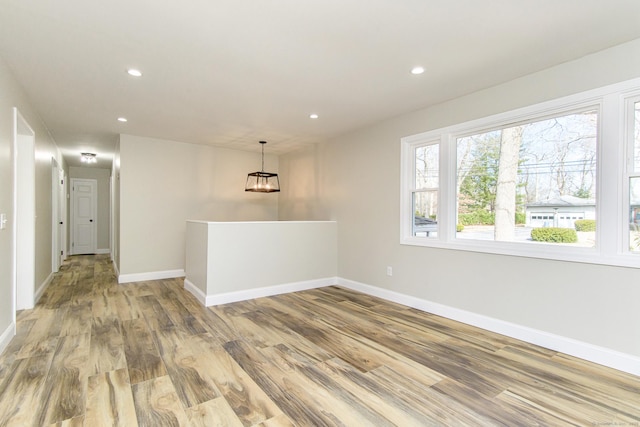 unfurnished room featuring wood finished floors, baseboards, and recessed lighting