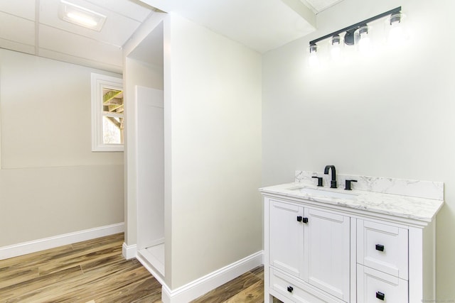 bathroom with baseboards, vanity, and wood finished floors