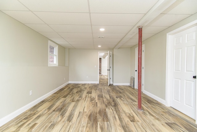 below grade area featuring a drop ceiling, visible vents, baseboards, recessed lighting, and wood finished floors