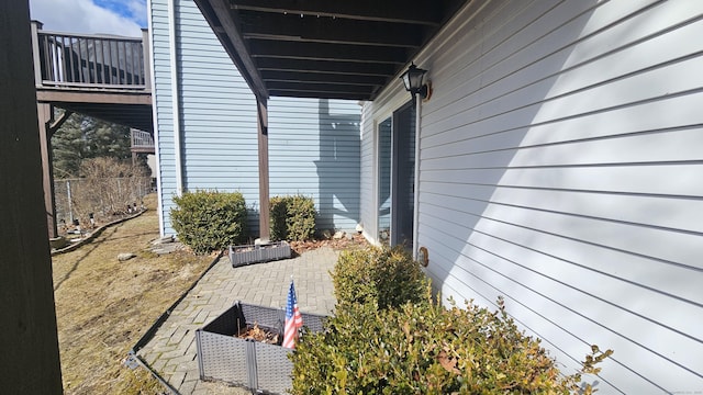 view of side of property with a balcony, a patio area, and fence