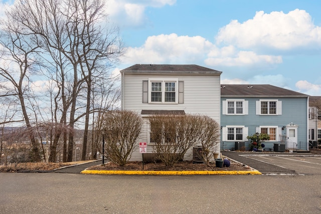 view of front of property with central air condition unit and uncovered parking