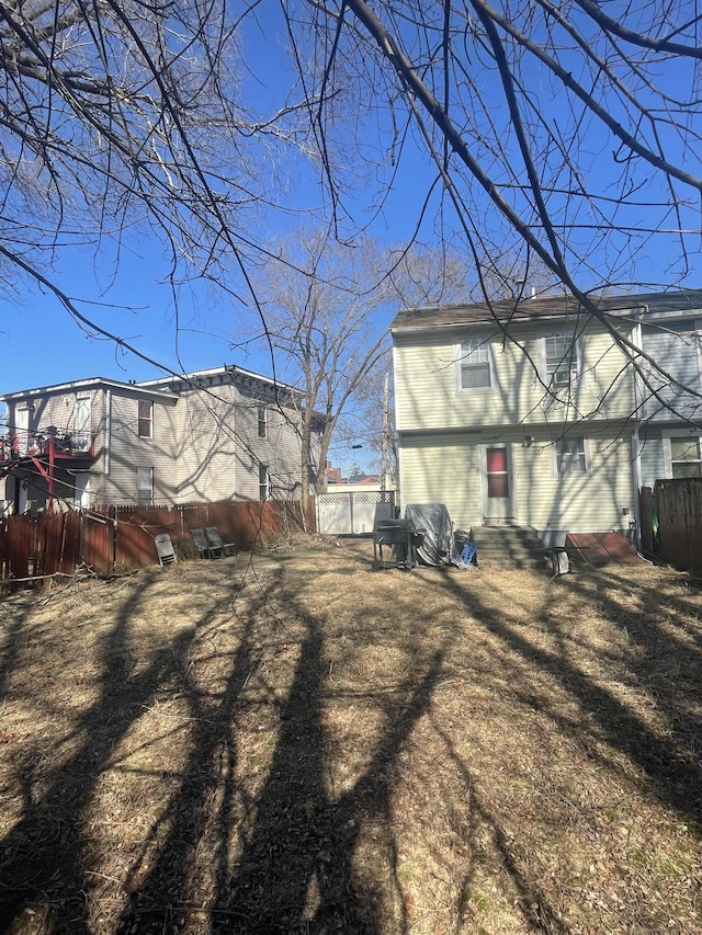 back of house featuring entry steps and fence