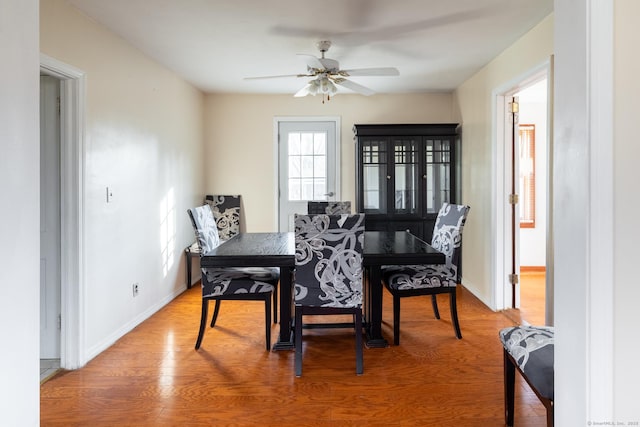 dining space with ceiling fan, baseboards, and wood finished floors