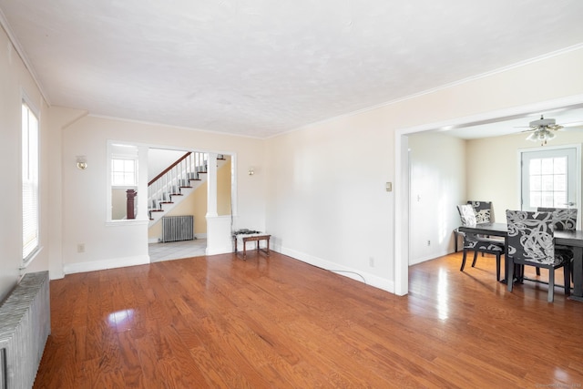 living room featuring ornamental molding, radiator heating unit, and wood finished floors