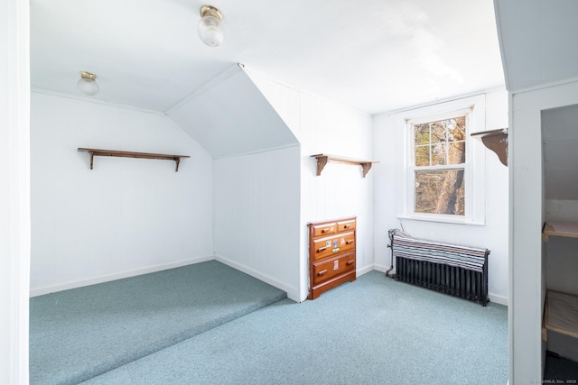 additional living space with baseboards, carpet floors, lofted ceiling, and radiator heating unit