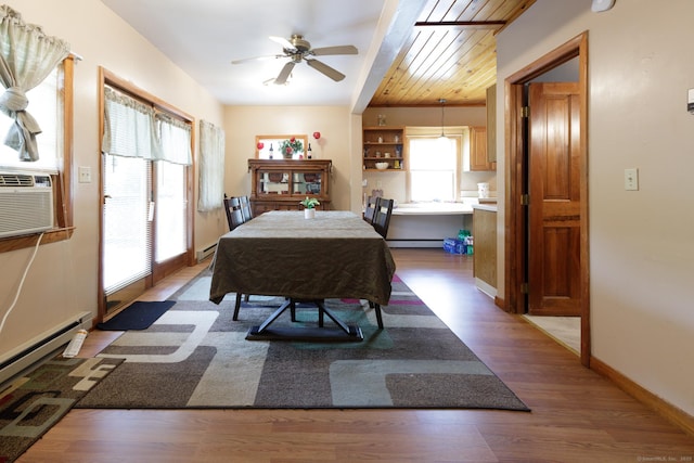 dining room with ceiling fan, a baseboard heating unit, wood finished floors, and baseboards